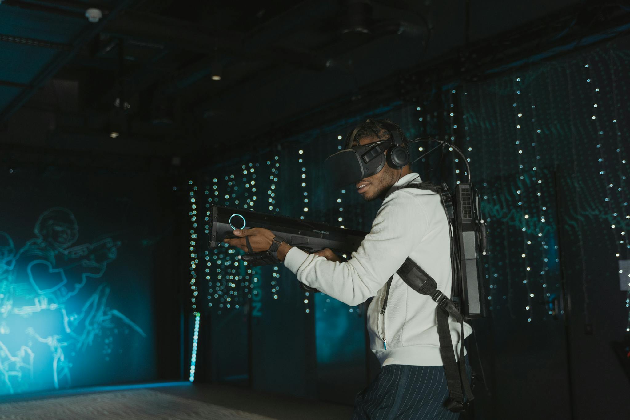 Adult man engaged in virtual reality gaming with VR headset and simulated weapon.