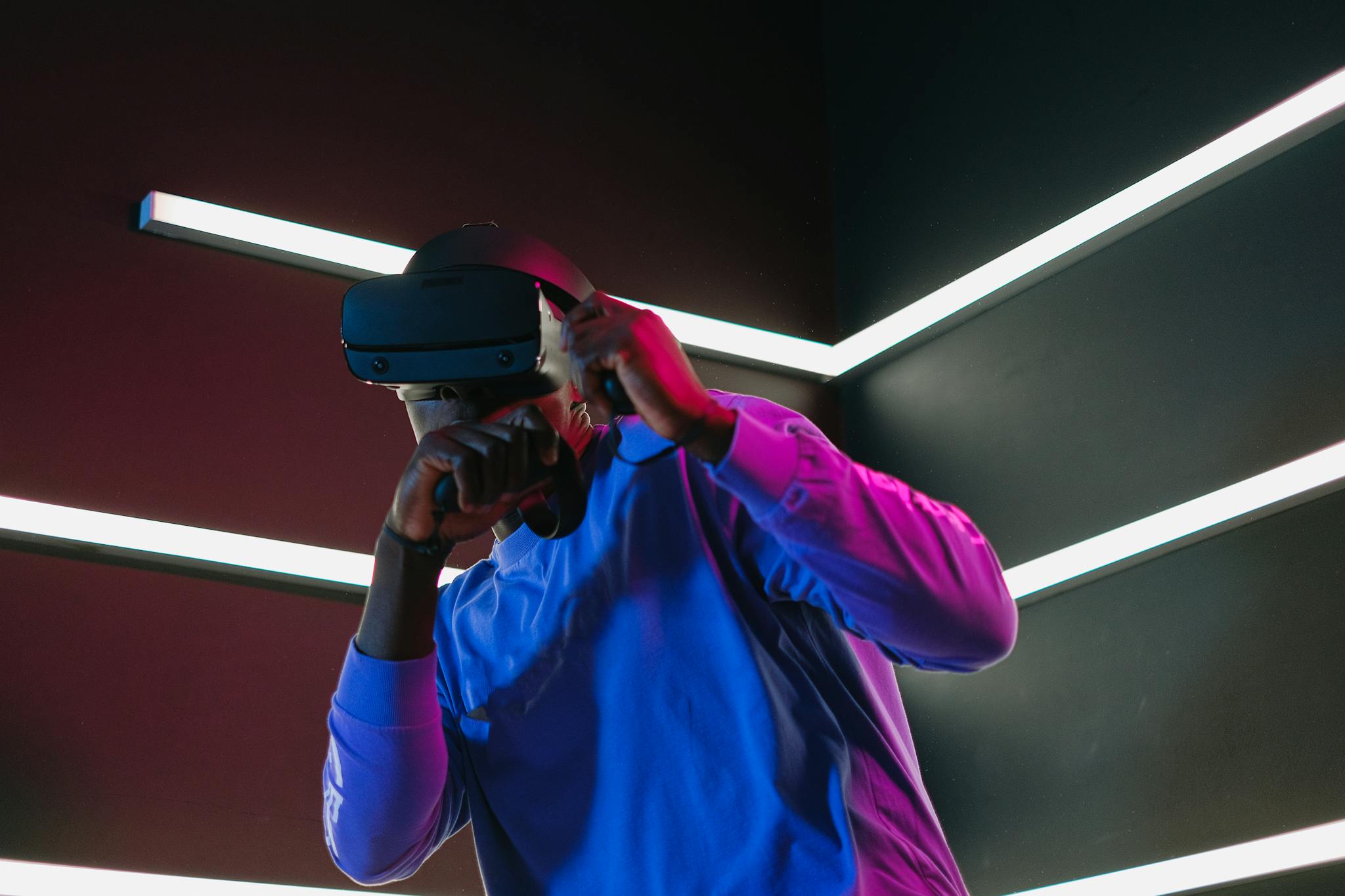 An adult man fully engaged in a virtual reality simulation with VR headset in a futuristic setting.